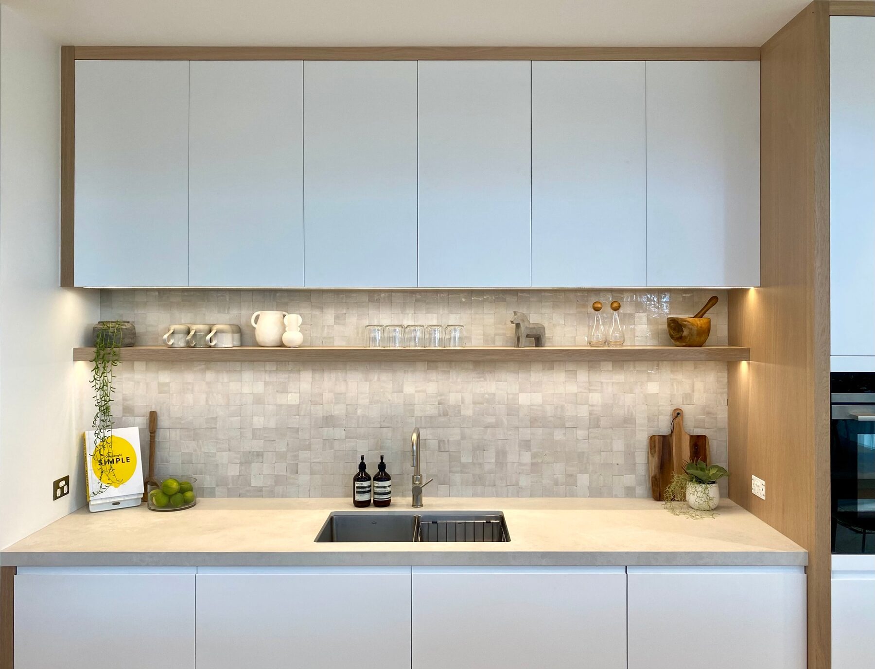Kitchen with timber island, concrete benchtop and tiled splashback